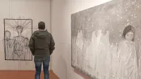 Detajl s postavitve v Pilonovi galeriji Ajdovščina, kjer je bila razstava na ogled do konca leta, prikazuje 
avtoportret Tee Curk Sorta iz žic (levo) in sliko velikega formata  Anje Kranjc iz cikla Utelešanje divjine.