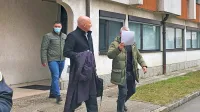 Marko  Hot  si  je  pred sodiščem  z listom  papirja  zakril  obraz,  z njim  
odvetnik Boštjan  Penko  in njegov  klient   Milutin  Stefanović.