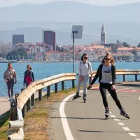 Obalna cesta, ki je zdaj rezervirana za pešce, kolesarje in rolkarje, je iz dneva dan dlje 
osončena in zato vse bolj priljubljena med rekreativci.