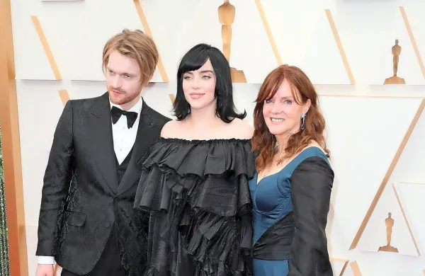 Billie Eilish  na podelitvi oskarjev v družbi brata Finneasa O'Connella in mame Maggie Baird, ki je blestela v obleki znamke 
Benedetti Life.