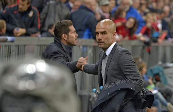 Pep Guardiola (desno) in nekaj mesecev starejši Diego Simeone 
gledata v različne nogometne smeri. 