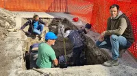 Vodja arheološke raziskave na Muzejskem trgu Luka Rozman 
(desno) ob sondi, v kateri so odkrili južno stranico nekdanje 
cerkve, v bližini pa tudi človeško okostje. 