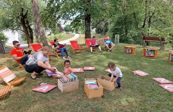 Knjižnica pod krošnjami v prijetnem hladu se je začela polniti že 
danes dopoldne. 