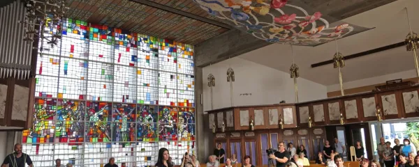 V cerkvi sv. Jožefa v Idriji je razstavljena korona vrtnica, ki so jo za 
umetnico Evo Petrič (stoji) sklekljale čipkarice iz vseh delov sveta, 
tudi idrijske. 