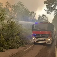 Gasilci  in ostali, ki pomagajo, skušajo na dveh cestah s sečnjo 
dreves ustvariti protipožarne preseke. 