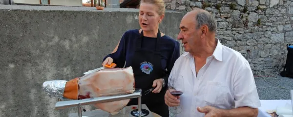 Dr. Stanislav Renčelj je vselej blizu pršuta. Reže ga Irena Ravbar Kovačič. 