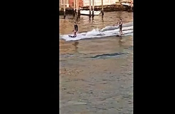 Dva mlajša moška sta se danes z deskama na električni pogon 
vozila po Velikem kanalu v Benetkah. 