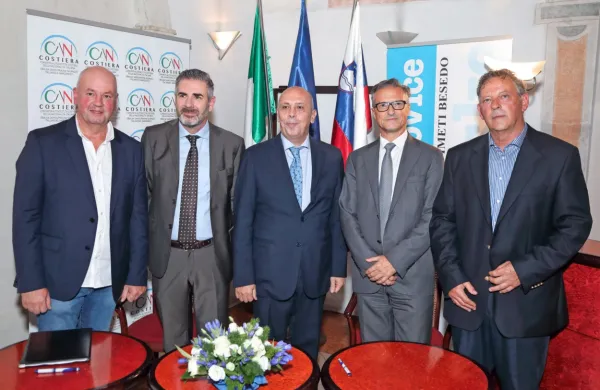 Svečani podpis pogodbe med Albertom Scherianijem iz Obalne 
samoupravne skupnosti italijanske narodnosti (levo) in direktorjem Primorskih novic Janezom Pavčnikom (desno) so pospremili (na sredini z leve proti desni) generalni konzul v Kopru 
Giovanni Coviello, veleposlanik Italije v Sloveniji Carlo Campanile  
in  poslanec italijanske narodnosti v slovenskem parlamentu Felice 
Žiža. 