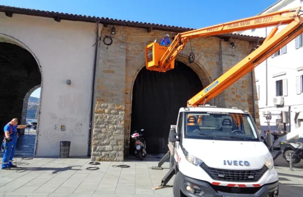 Delavci Javne razsvetljave Ljubljana že  nameščajo novoletno 
okrasje pri Taverni.