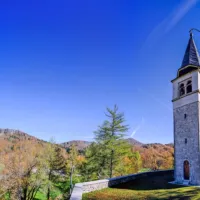 Nad Lokvami se dviga cerkvica Sv. Antona Padovanskega. Levo je pogled na travnik, kjer so pozimi urejene tekaške smučine.