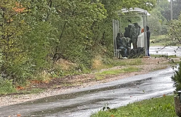 Z dežja pod kap? Skupina prebežnikov si je  zatočišče pred dežjem 
našla  na avtobusni postaji v Podgorju.  