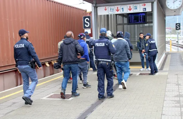 Trije slovenski in en italijanski policist so migrante z vlaka 
pospremili v stavbo železniške postaje. 