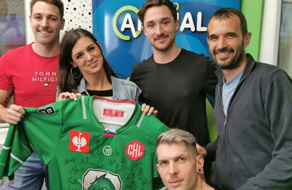 Aktualovca Žana Vidmar in Klemen Bunderla, novinar EkipeSN 
Andrej Miljković in hokejista Olimpije Žiga Pance in Carl Neill 
ponosno napovedujejo dražbo dresa Olimpije za malega Urbana. 

