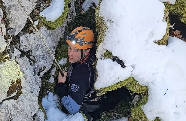 Nejc Velikonja med spustom v najvišje ležeče brezno v Trnovskem 
gozdu.  