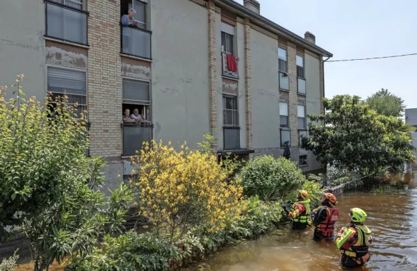 Prostovoljci spremljajo potapljača in prostovoljca italijanskega 
Rdečega križa, ki prinašajo tople obroke in pitno vodo družinam, 
izoliranih zaradi poplav v kraju Conselice. 