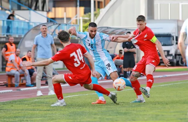 Domači trener Agron Šalja (v ozadju) je lahko le nemočno opazoval 
vrnitev Gorice v drugo ligo, potem ko je bil Aluminij (v rdečih 
dresih) na dveh dvobojih  boljši tekmec.    