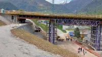 Kolesarska steza poteka pod mostom in naprej čez brv  nad Tolminko in proti Mostu na Soči. 