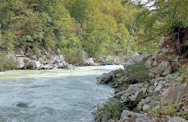 Iz modrega čolna (v daljavi) je  ob trku v skalo v Sočo popadalo več 
Kanadčanov in Američanov. 