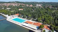 Če bo družba Adria želela graditi  na območjih, na katerih  občina  
ne dovoli več turistične  dejavnosti - gre za vzhodno območje, kjer 
je kamp, bo veljalo, da izkazuje pravni interes in bo lahko v 
postopku izdaje gradbenega dovoljenja občini očitala protiustavnost in nezakonitost. 