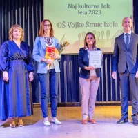 Priznanje za naj kulturno šolo sta za OŠ Vojke Šmuc prevzeli 
pomočnica ravnatelja  Veronika Zubin (druga z leve) in učiteljica 
slovenščine Deana Protner (tretja z leve). Ob njiju sta pomočnik 
direktorja Javnega sklada za kulturne dejavnosti dr. Tomaž 
Simetinger in  Klavdija Gregorin Štiftar, koordinatorica območne 
izpostave JSKD Domžale. 