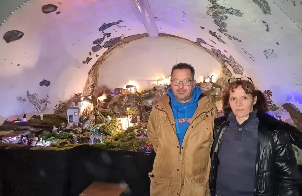 Aleš in Blanka Logar pred jaslicami, ki že tretje leto krasijo 
polkrožno nišo na njunem vrtu. 