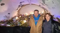 Aleš in Blanka Logar pred jaslicami, ki že tretje leto krasijo 
polkrožno nišo na njunem vrtu. 