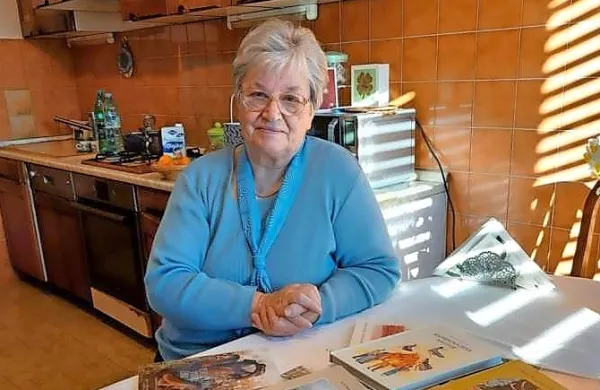 Jasna Majda Peršolja ob svoji bogati zbirki knjig.