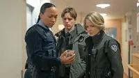 Evangeline Navarro (Kali Reis levo) z Liz Danvers (Jodie Foster) in 
njunim mladim ter obetavnim pomočnikom Peter Prior (Finn 
Bennett) 