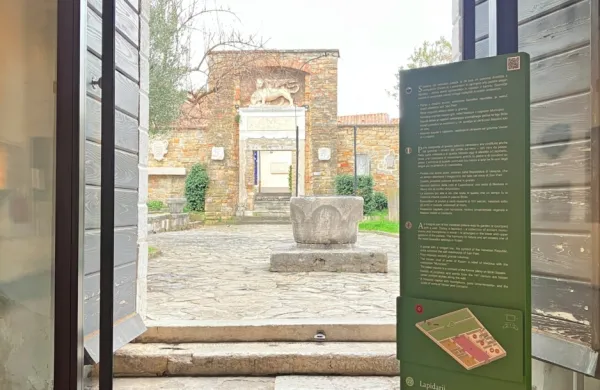 Stoječi totem, ki označuje Lapidarij v vrtovih palače.