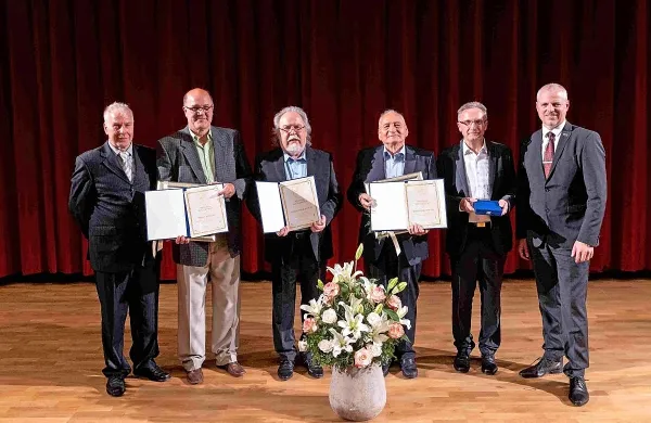 Priznanje in plakete v roke &scaron;tirih zaslužnih mož