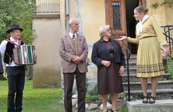 Družina Črv, pred rudarsko hišo Giser, pozdravlja povabljene na 
srebrno poroko rudarskega nadzornika Petra in žene Marjance.