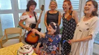  Nasmejana druščina deklet:  104-letna Olga Ogrin, ob njej pa (z 
leve) pevka Marjetka Popovski, podžupanja Jasna Softič, Olgina 
vnukinja Romina Ponti in hčerka Nada Džafič. 
