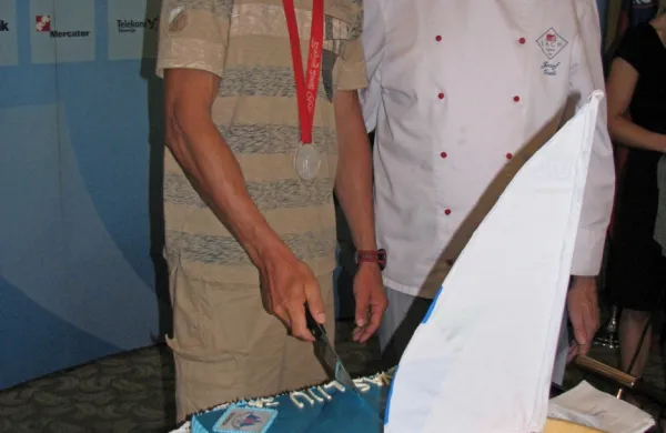 Razrez torte v slovenski hiši ob jadralski medalji Izolana Vasilija Žbogarja (levo) na igrah v Pekingu 
leta 2008. 