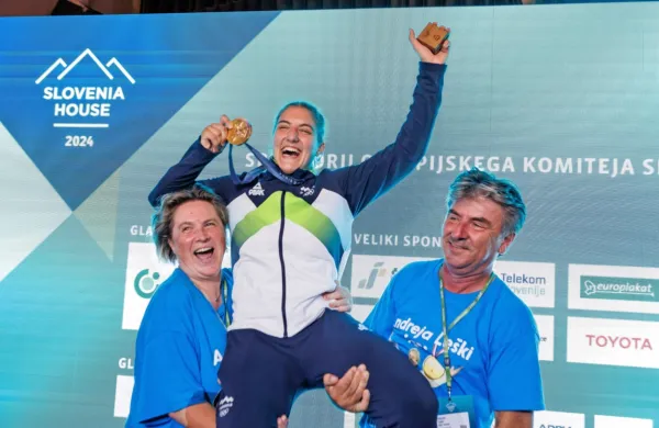 Zlata olimpijka Andreja na rokah mame Irene in očeta Danila.