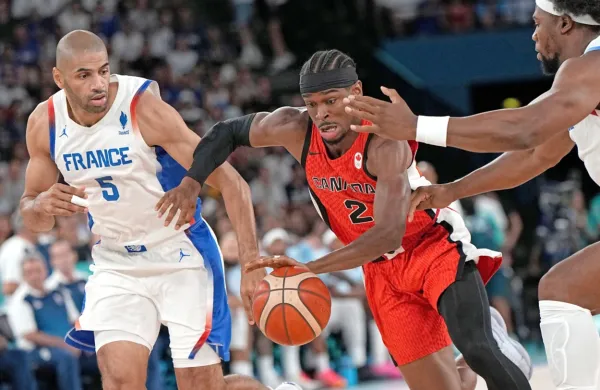 Nicolas Batum (levo) je v četrtfinalu košarkarskega turnirja dihal 
za ovratnik desetletje mlajšemu Shaiju Gilgeousu-Alexandru (z 
žogo).  