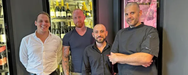Pred vinsko vitrino in zorilnico mesa v Il Bilaterale so (z leve) vodja strežbe Josip Stevanja, lastnik Rok Trobec, barman Tim Bratuša 
in glavni kuhar Grega Vovk.
