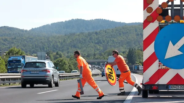 Zapora ceste v nastajanju. Tek med avtomobili  s 30 kilogrami v 
rokah ...  