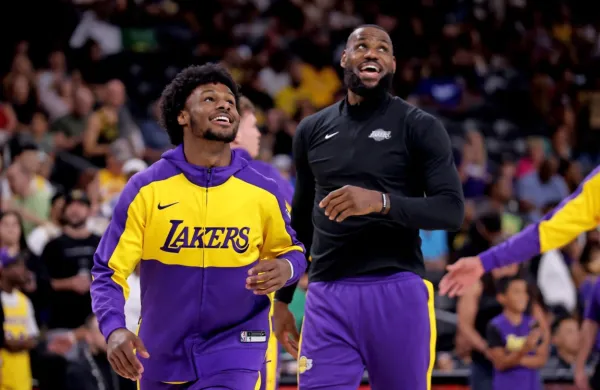 Bronny (levo) na svoji prvi tekmi v ligi NBA z očetom LeBronom.