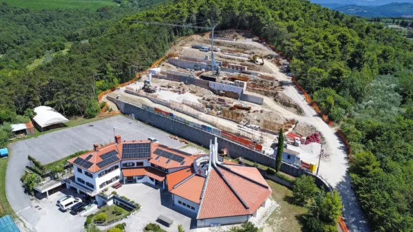 Podporni zid za župnijsko cerkvijo je sedaj v smeri proti gozdu 
daljši za 12 metrov - tega podaljška gradbeno dovoljenje ne 
omenja, zato pa projekt za izvedbo. Ali bi teh nekaj podaljšanih 
metrov gradbeno dovoljenje moralo omenjati ali ne, si sodelujoči 
niso enotni. 