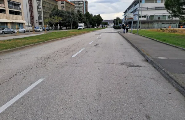 Nespodobno cestišče in neurejen pločnik na robu mesta