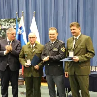 Lovci Boris Cunja, Mladen  Miklavčič (na  fotografiji prvi  in  tretji  z  
desne)  in  Bojan  Švab  so pred dobrim letom rešili voznico, ki je nad 
vasjo Bezovica pod Kraškim robom zapeljala s ceste in obtičala tik 
pred prepadom v avtu.