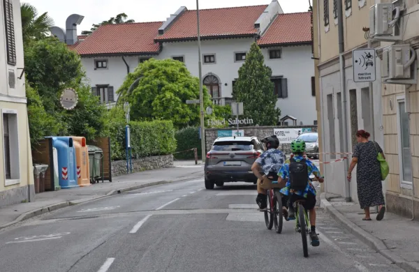 Opozorilna tabla  in naprava za merjenje hitrosti sta v prometni  situaciji z na&scaron;e fotografije povsem na mestu. Ali bo  k umirjanju  prometa pomagal &scaron;ele večerni soj sveče v spomin na koga, ki bo tu  preminil?
