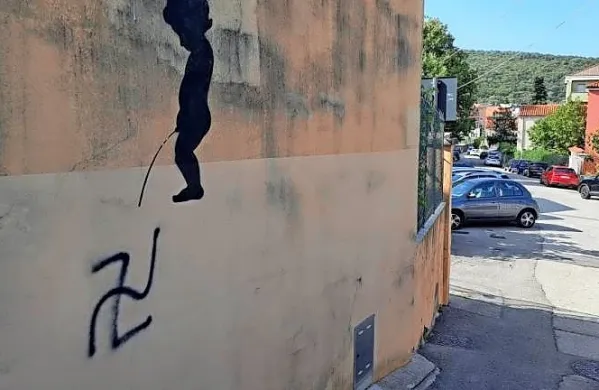 Nad svastiko ob svetoivanskem Marijinem domu je upodobil 
dečka, ki lula na odvratni simbol