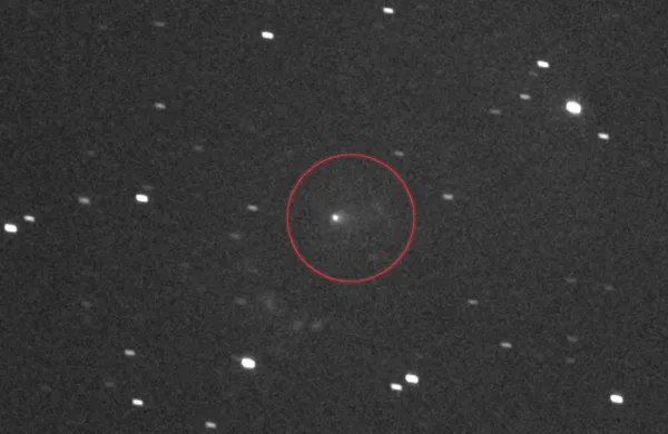 Fotografija prikazuje medzvezdni komet 3I/ATLAS, obkrožen na sredini
