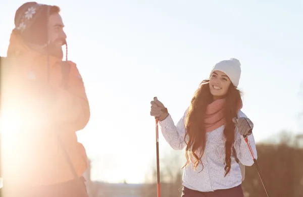 Pretty young skier talking to her husband during trip