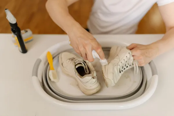 Process of cleaning white dirty sneakers with scrubbing brush and detergent, removing stubborn stains from footwear in white basin, preserving shoe hygiene and appearance thorough washing work.,Image: 1012490791, License: Royalty-free, Restrictions:, Model Release: no, Credit line: Dmitrii Dikushin/Alamy/Profimedia