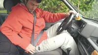 voznik med zapenjanjem varnostnega pasuvarnostni pas v avtomobilu
