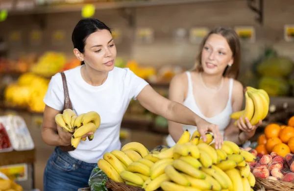 Young and adult women buyers choosing bunch of fresh bananas in vegetable shop,Image: 1076978470, License: Royalty-free, Restrictions:, Model Release: no, Credit line: Iakov Filimonov/Alamy/Profimedia