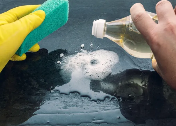 Caucasian man, with a green sponge in his hand and yellow gloves, adds vinegar to baking soda to clean a surface.,Image: 625908450, License: Royalty-free, Restrictions:, Model Release: no, Credit line: Daniele De Vivo/Alamy/Profimedia