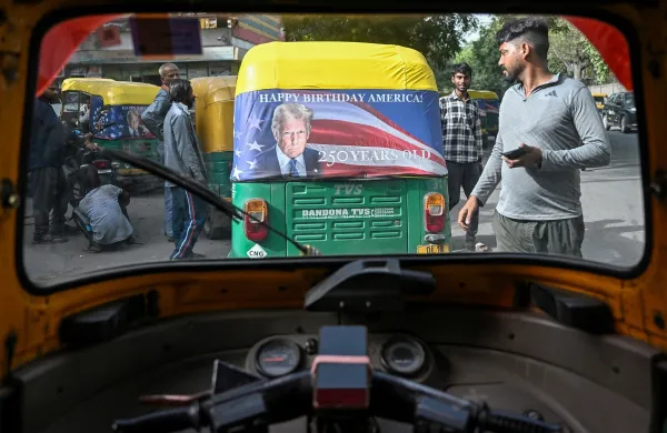 Workers fix a poster featuring US President Donald Trump on an autorickshaw in New Delhi on May 21, 2026 marking the 250th anniversary of American independence. New Delhi's iconic auto-rickshaws have received a Donald Trump-themed makeover to mark the United States' 250th Independence celebrations and the upcoming India visit of Secretary of State Marco Rubio. Across the sprawling megacity, the US embassy said it is providing thousands of the vehicle covers emblazoned with Trump's face and the US flag for the ubiquitous three-wheeled taxi rickshaws plying the city.,Image: 1103768963, License: Rights-managed, Restrictions:, Model Release: no, Credit line: Arun SANKAR/AFP/Profimedia